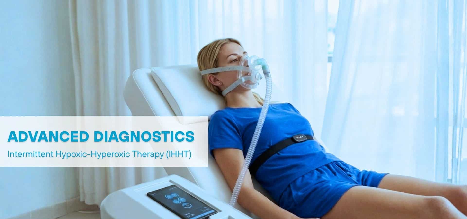 A woman lying on a medical chair receiving advanced diagnostics using a breathing mask for intermittent hypoxic-hyperoxic therapy (IHHT), with clinical equipment beside her in a bright treatment room