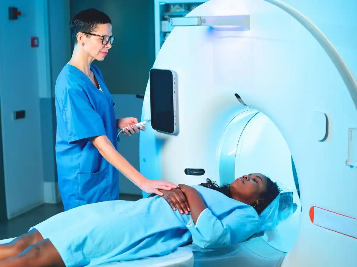Patient undergoing an MRI scan with assistance from a medical professional.