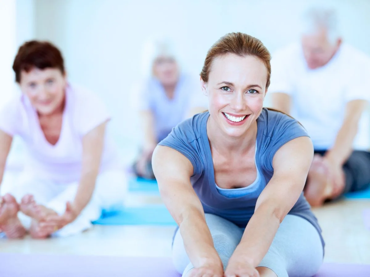 Group of adults stretching during a guided fitness class to support healthy aging and overall wellness.